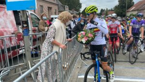 Burgemeester Tania De Jonge geeft bloemen aan Belgisch kampioen Nio Vandervorst (Acrog Tormans Balen BC) bij de start van de Beker van België U17 Nieuwelingen wielerwedstrijd Grote prijs Tania De Jonge Nederhasselt 2021